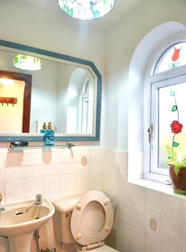 a bathroom with a toilet and a sink and a window at The Peak View - Holmfirth in Cartworth