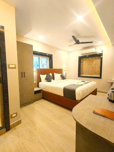 a bedroom with two beds and a ceiling fan at Mio Hotel in Hyderabad