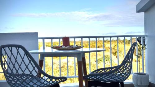 a table and two chairs on a balcony with a view at Zephyr House Ocean Breeze with Pool in Grand Gaube