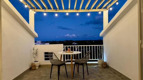 a patio with a table and chairs on a balcony at Zephyr House Ocean Breeze with Pool in Grand Gaube