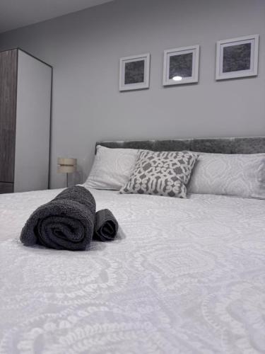 a bed with towels and pillows on top of it at studio flat near NEC, Solihull & Airport. Short & Long stay Contractors HS2, NHS in Solihull