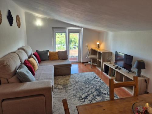 a living room with a couch and a television at Alojamento 3 vistas in Sintra