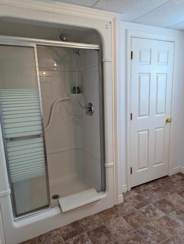 a shower with a glass door in a bathroom at The Convenient Suite in Charlottetown