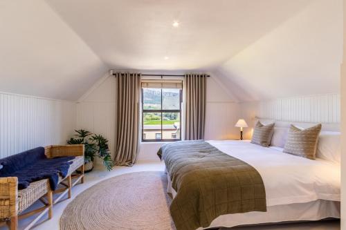 Un dormitorio con una cama grande y una ventana. en Franschhoek Charm, en Franschhoek