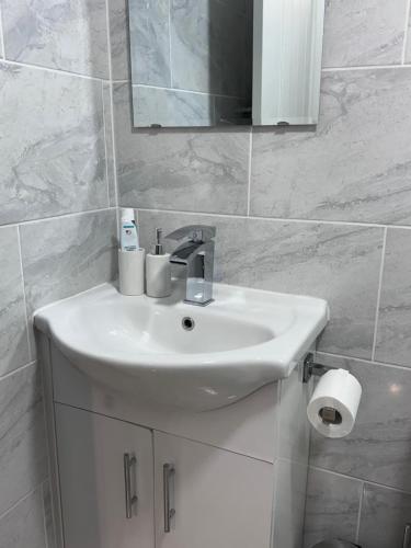 a white bathroom with a sink and a mirror at studio flat near NEC, Solihull & Airport. Short & Long stay Contractors HS2, NHS in Solihull