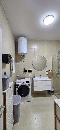 a bathroom with a sink and a toilet and a tub at Agel Apartment in Tirana