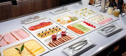 a table with many different types of food on it at B&B HOTEL RZESZÓW CENTRUM in Rzeszów