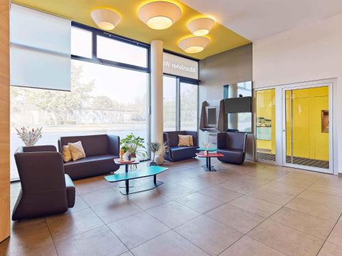 a lobby with couches and a table in a building at B&B HOTEL Münster Hafen in Münster