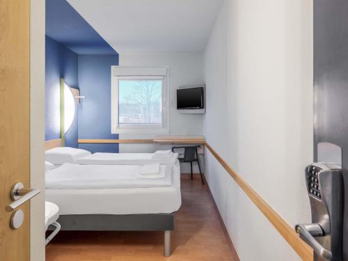 a hospital room with three beds and a window at B&B HOTEL Willich in Willich