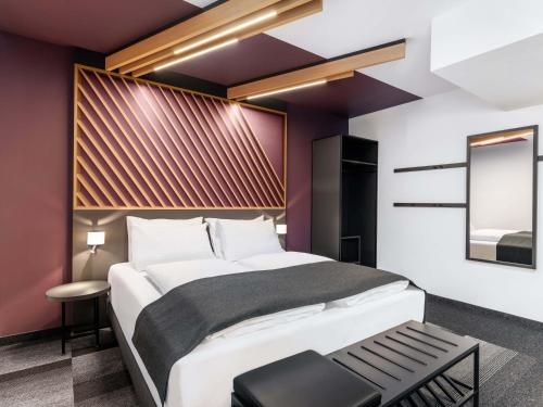 a bedroom with a large white bed and purple walls at B&B HOTEL Wien-St-Marx in Vienna