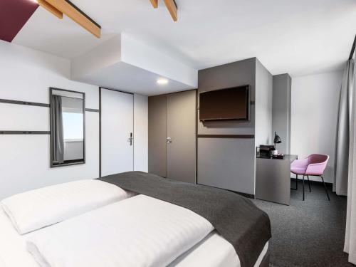 a hotel room with a bed and a tv at B&B HOTEL Wien-St-Marx in Vienna