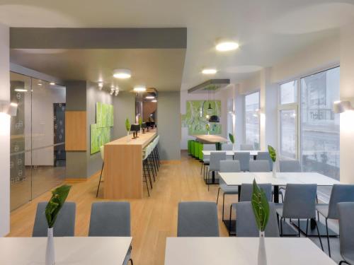 a restaurant with tables and chairs and a bar at B&B Hotel Paderborn in Paderborn