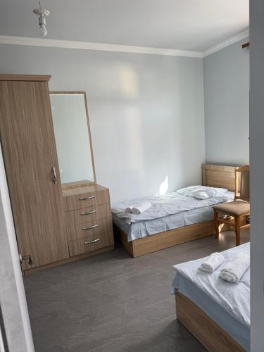 a bedroom with two beds and a dresser and a mirror at Liga Hotel and Restaurant in Shinuhayr