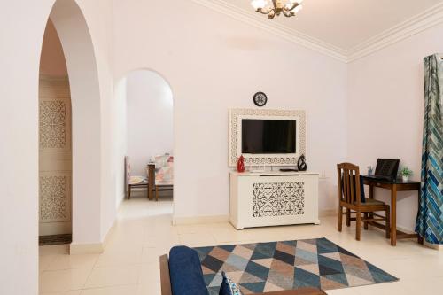 ein Wohnzimmer mit einem Fernseher an einer weißen Wand in der Unterkunft Saurina's Beach Retreat near Candolim Beach in Goa