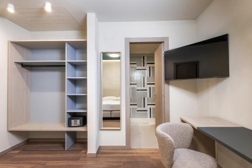 a room with a mirror and a bedroom at Primo Piano Rooms in Aversa