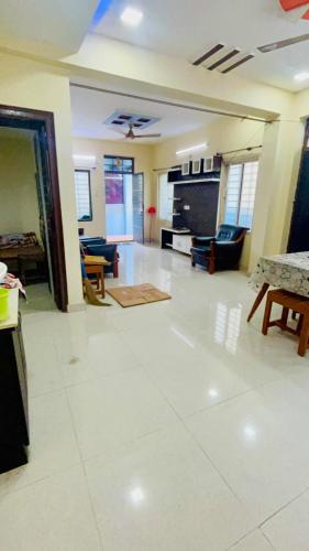 a large living room with a white tile floor at Lakshmi Nilayam in Warangal
