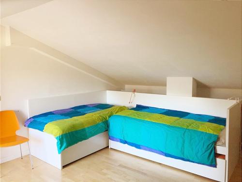 a bedroom with a bed with colorful sheets at Peter giardino e casa sul lago in Bracciano