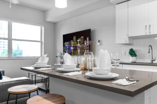 a kitchen with a table with plates and wine glasses at Sunny 1BR Unit With Free Parking Prime Location in Miami