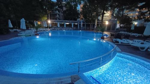 a large swimming pool at night with chairs and tables at Excelsior Prince ApartHotel in Sunny Beach