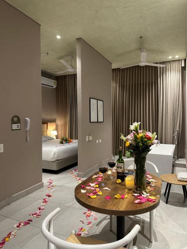 a room with a table with flowers and wine glasses at FR Hotel in Ibagué