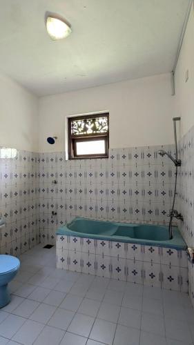 a bathroom with a tub and a toilet at Zen Bentota Ayurveda Resort in Bentota