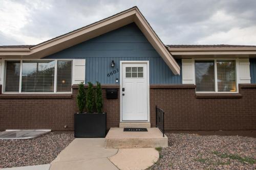 a blue house with a white door at Home With Sunset Patio, Fenced Backyard, And Quick Access To Denver - Gray Street in Arvada