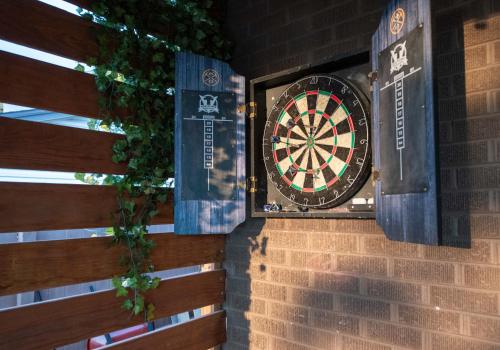 a dart board on the side of a brick wall at Home With Sunset Patio, Fenced Backyard, And Quick Access To Denver - Gray Street in Arvada