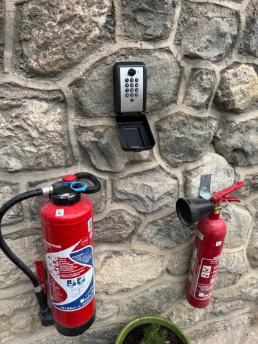 two fire hydrants are attached to a stone wall at appartement 4 personnes yvetot maurienne express in Saint-Jean-de-Maurienne
