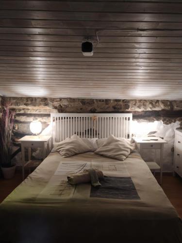 a bedroom with a large white bed with two tables at BIDEARTEAN, Caserío vasco, Recién reformado in Záitegui