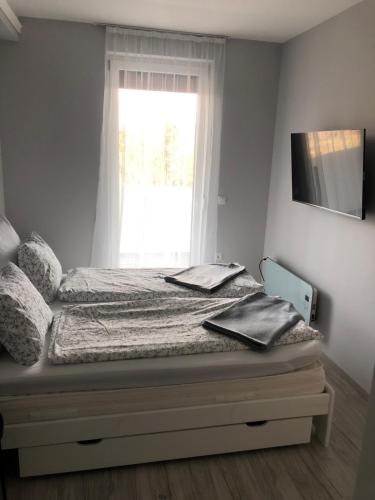 - un lit dans une chambre avec fenêtre dans l'établissement Luca Apartman, à Keszthely