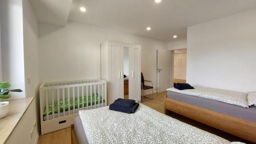a bedroom with two beds and a crib in it at Fewo Gerda im schönen Odw in Mörlenbach