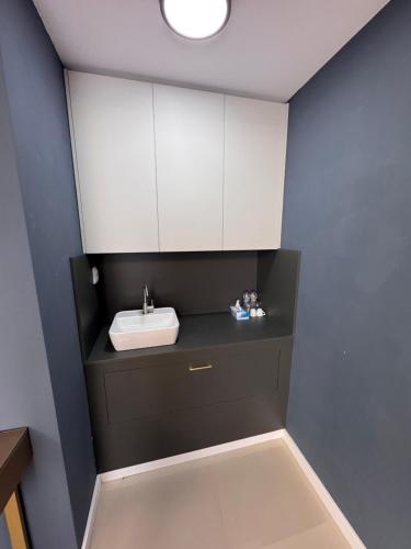 a bathroom with a sink and white cabinets at AWA boutique in Voluntari