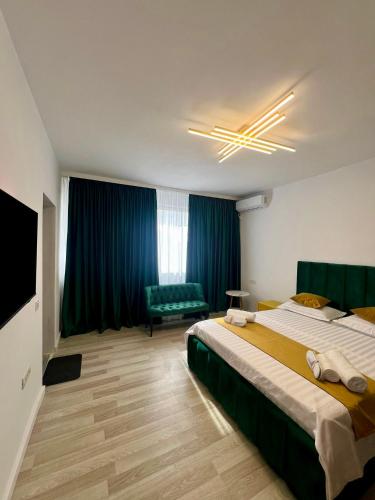 a bedroom with a large bed and a green couch at AWA boutique in Voluntari