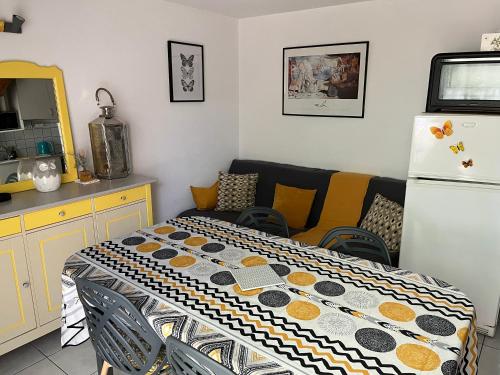 een keuken met een tafel, een bank en een koelkast bij Pavillon de vacances chic et moderne in Plage dʼArgelès