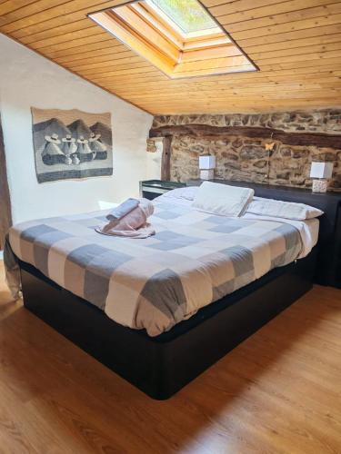 a large bed in a room with a wooden ceiling at BIDEARTEAN, Caserío vasco, Recién reformado in Záitegui