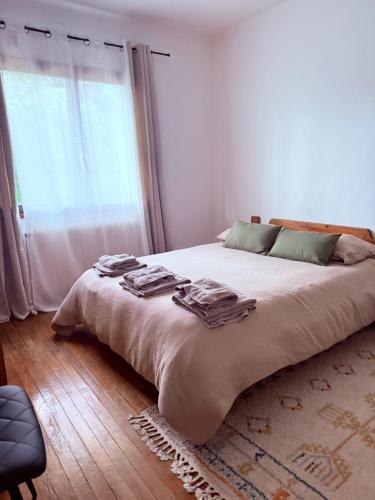 a bedroom with a large bed with a large window at Maison familiale , piscine chauffée - Jardin - Toulouse in Cugnaux
