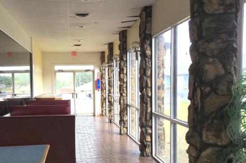 a waiting room with a stone wall and windows at River Valley Inn and Suites in Fort Smith