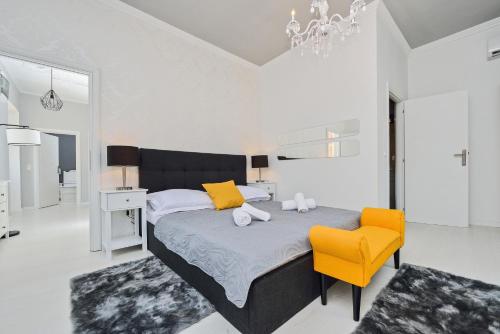 a bedroom with a bed and a yellow chair at Rooms Urban design in Zadar