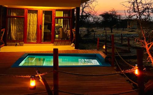 a swimming pool on a deck with a house at Furaha Luxury Lodge in Mto wa Mbu