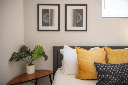 a bed with pillows and a plant on a wall at Private 2BR Retreat Near Denver - Gray St in Arvada