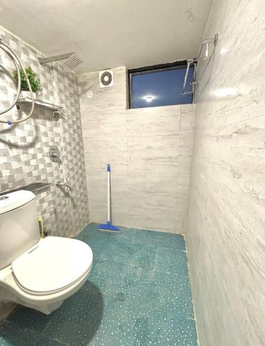 a bathroom with a toilet and a window at Spatii Apartment in Rishīkesh