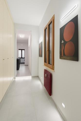 a hallway with white walls and paintings on the wall at Casa Chanel in Rome