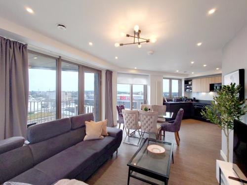 a living room with a couch and a table at Luxury Three bed Apartment by London ExCeL in London