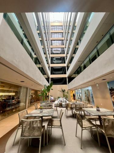 a restaurant with tables and chairs and a ceiling at Refúgio do Mar 703 - Condomínio Edifício Ritz Suítes Home Service in Maceió