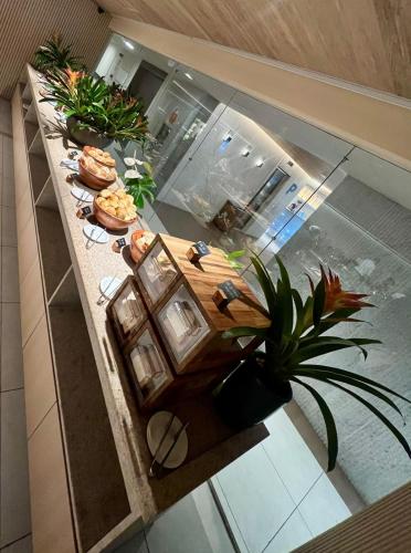 an overhead view of a kitchen with a table with plants at Refúgio do Mar 703 - Condomínio Edifício Ritz Suítes Home Service in Maceió