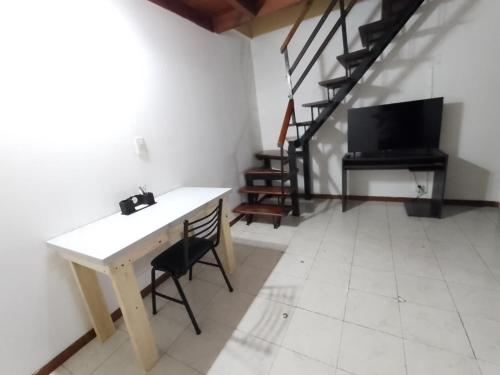 a room with a table and a television and stairs at El Refugio al Norte del Fin del Mundo A in Río Grande