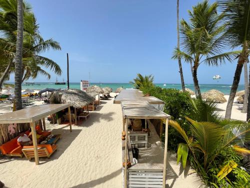 a beach with chairs and umbrellas and the ocean at CARIBBEAN Studios LOS CORALES BEACH WIFI POOL & SPA in Punta Cana