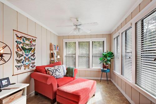 a living room with a red chair and a fan at Central Condo, Community Pool and Gym, 10 Min to East Beach in Saint Simons Island
