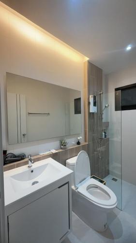 a bathroom with a white toilet and a sink at Norden Barn B&B in Chiang Mai