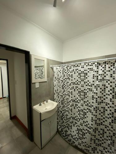 a bathroom with a sink and a shower curtain at La Tranquera 2 in La Paz